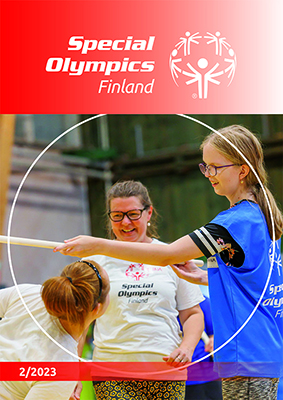 Lehden 2/2023 kansikuva: Special Olympics -valmentajanainen ohjaamassa hymyillen nuorta vaaleahiuksista voimistelijatyttöä liikuntasalissa.